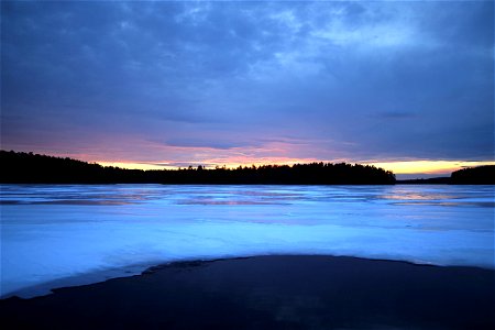 Sunset on the Horizon of Frozen Lake photo