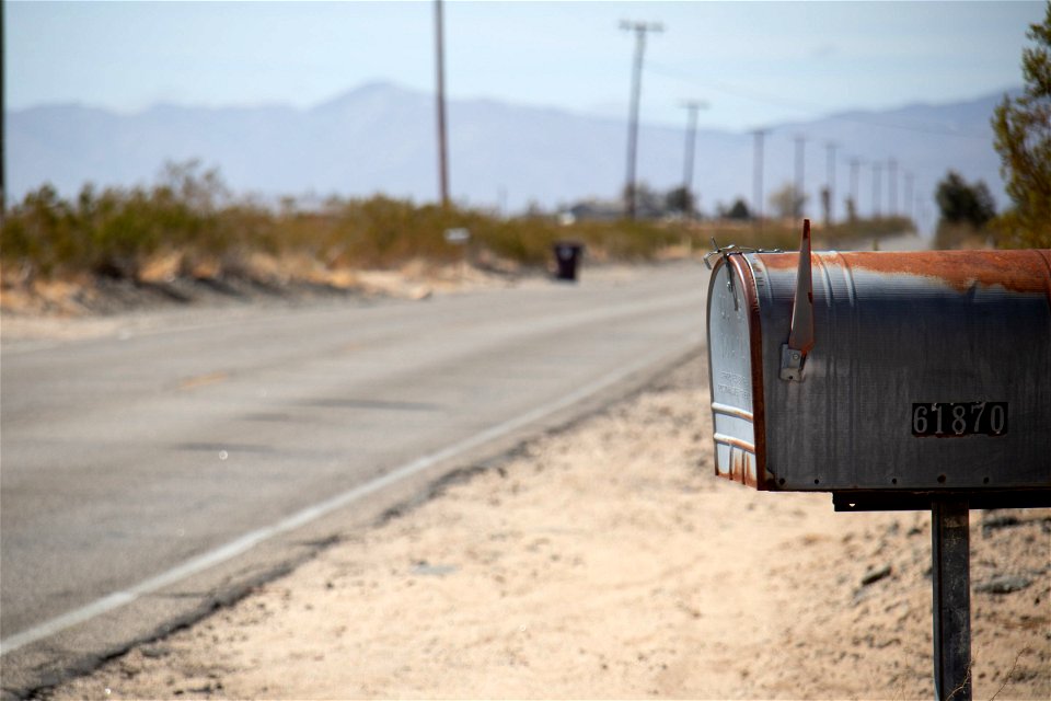 Rusty Mailbox Near Paved Road photo