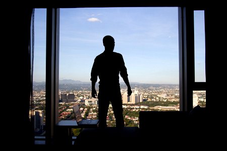Man In Front Of Window With City View photo