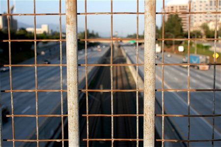 Blurry Divided Highway Beyond Wire Mesh Fence photo