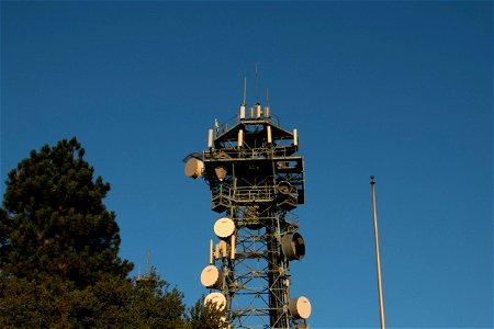 Top Of Radio Tower Next To Tree photo