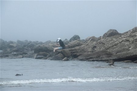 Woman Sitting On Rock Near Water photo