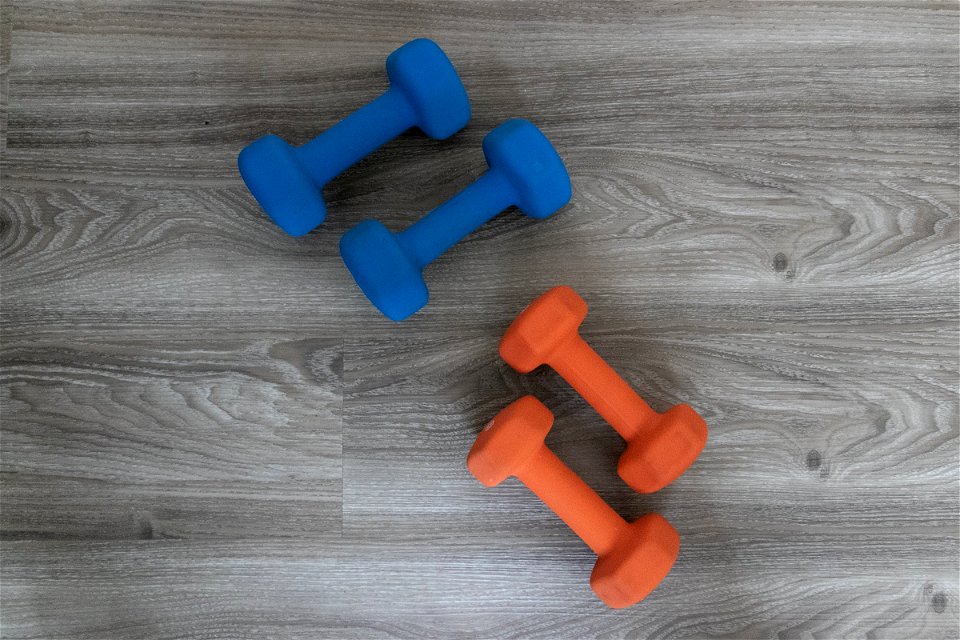 Two Sets Of Dumbbells On Wood