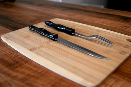 Steak Knife And Fork On Cutting Board photo