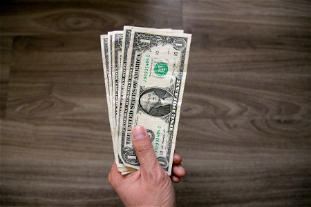 One Us Dollar Bills In Left Hand