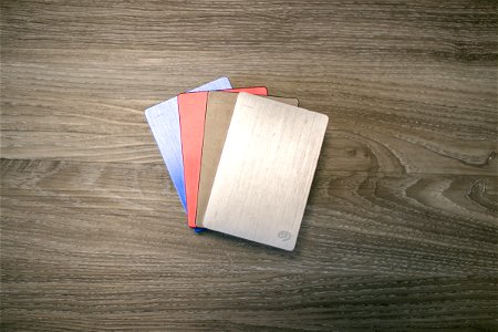 Four External Hard Disks On Wooden Surface photo