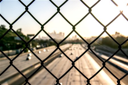 Blurry Traffic Through Chain Link Fence