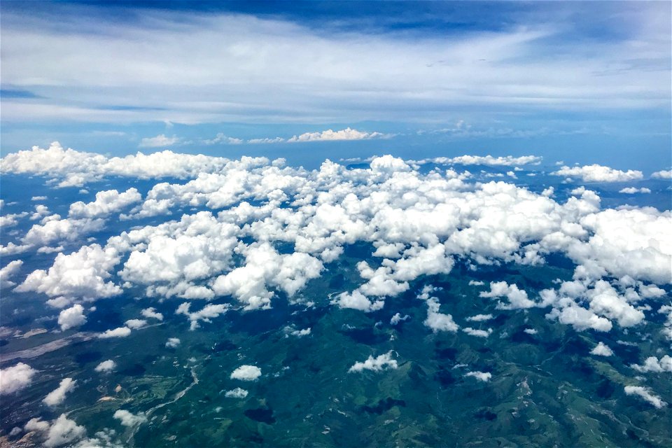 Small White Fluffy Clouds Above Mountains And Hills