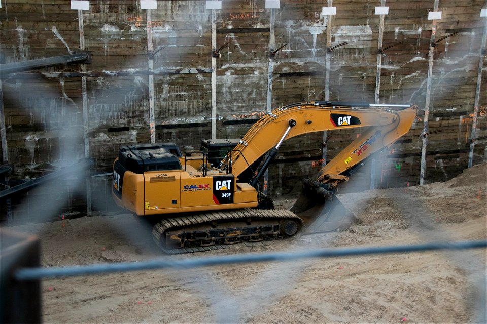 Excavator Through Blurry Chain Link Fence