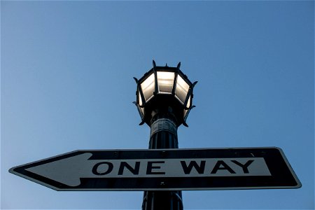 One Way Sign On Street Light Pole photo
