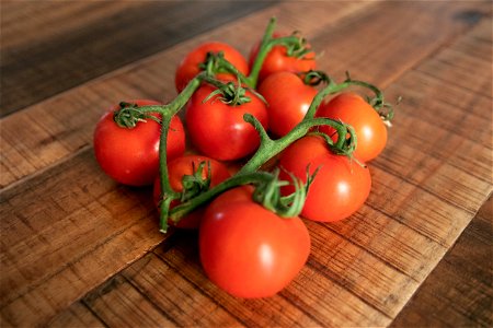 Handful Of Small Tomatoes On Wooden Surface photo