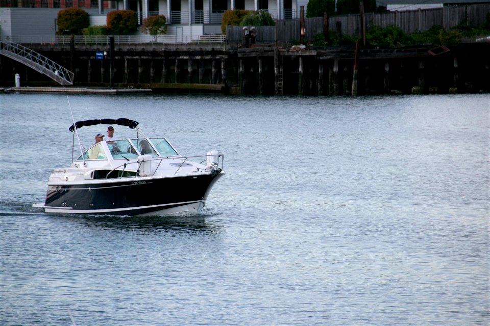 People On Motorboat On Water Near Shore photo