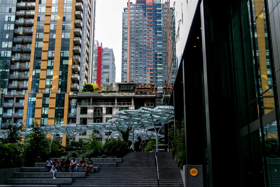 Tall Buildings Behind People Near Stairs