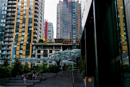 Tall Buildings Behind People Near Stairs photo