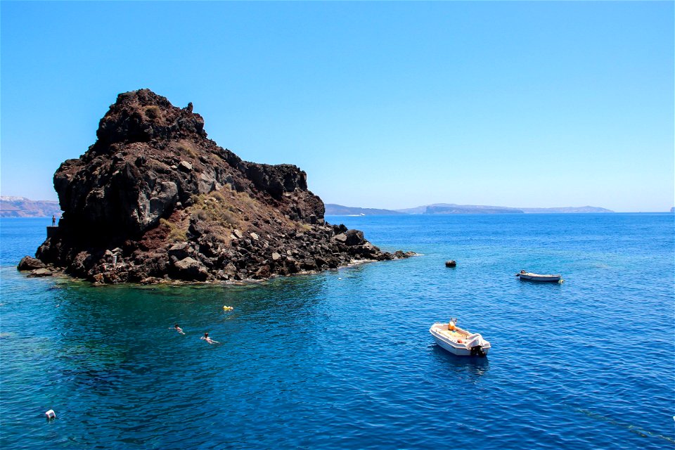 Boats And People Near Small Rock Islet