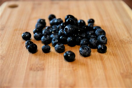 Handful Of Blueberries On Wooden Chopping Board
