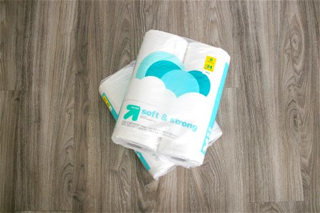Two Toilet Paper Packages On Wooden Surface photo