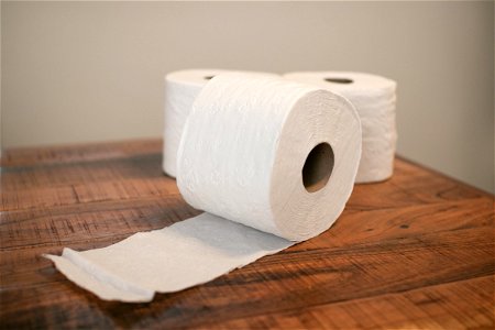 Three Toilet Paper Rolls On Wooden Table