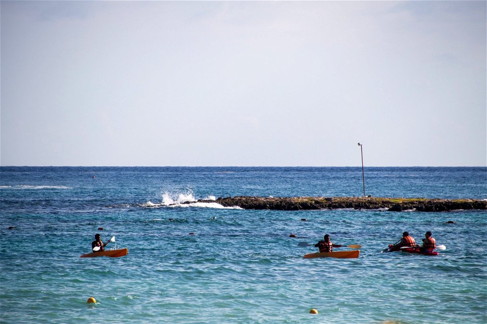 People Rowing On Small Boats Near Shore photo