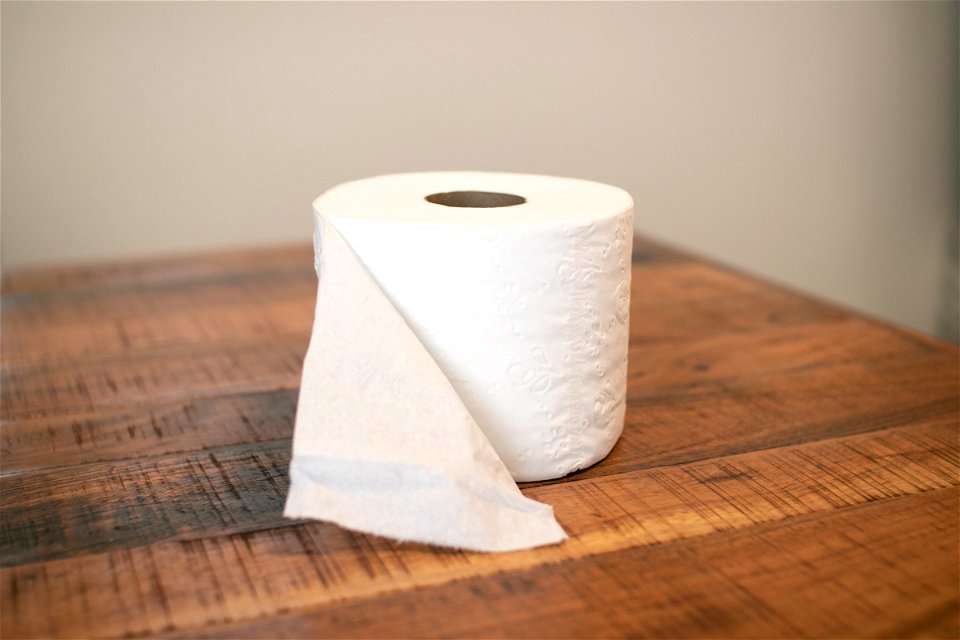 Open Toilet Paper Roll On Wooden Surface