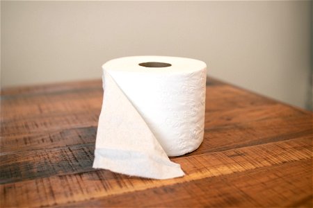 Open Toilet Paper Roll On Wooden Surface photo