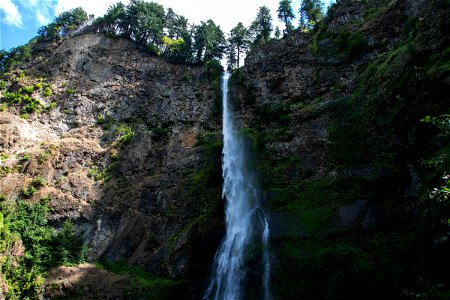 Long Narrow Waterfall On Mountain Cliff photo