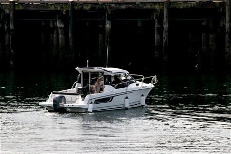 Two People On Boat Near Wooden Pier photo