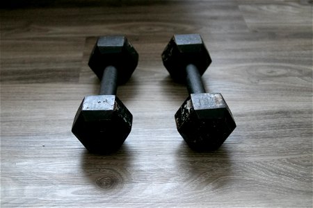 Pair Of Black Dumbbells On Wooden Surface photo
