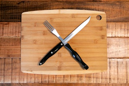 Steak Fork And Knife On Cutting Board photo