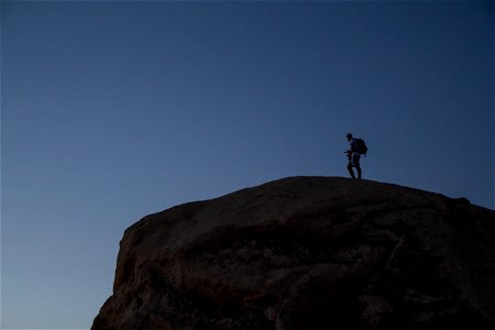 Man With Backpack On Rock photo