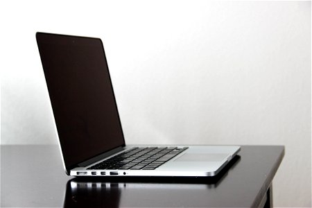 Open Macbook Laptop On Dark Glossy Table photo