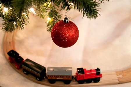 Toy Train On Tracks Below Hanging Red Bauble Ornament