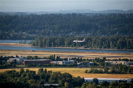 Commercial Plane Preparing To Land Near River And Forest photo