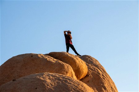 Man Photographing From Top Of Rock Formation photo