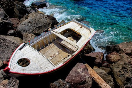 Old Wooden Boat On Rocks Near Water photo