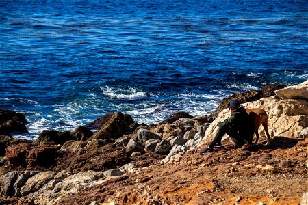 Woman And Dog On Rocky Shore photo