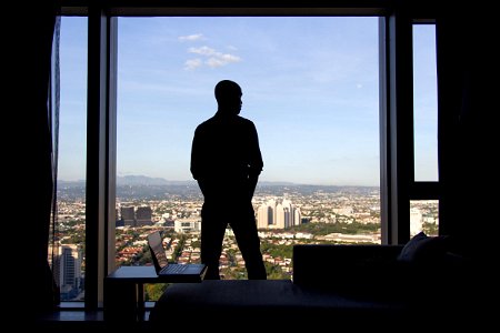 Man Standing Near Hotel Window