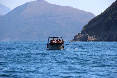 People On Boat In Water Near Mountains photo