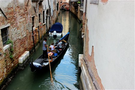 Tourists In Gondola In Venice Canal photo