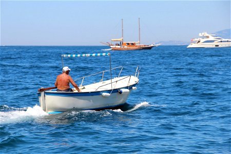 Shirtless Man On Moving Boat In Water photo