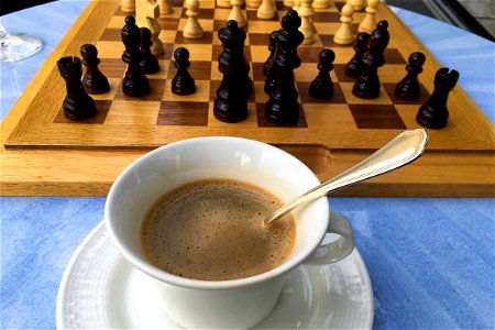 Cup Of Coffee Next To Chessboard On Table