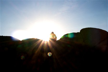 Silhouette Of Person On Rock Against Sunshine