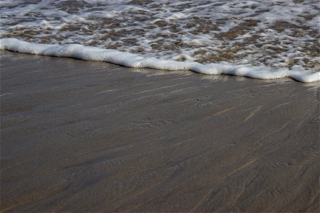 Sea Foam On Sandy Shore