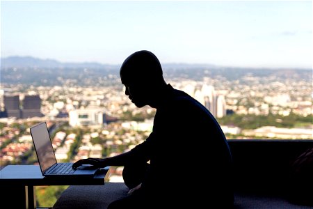 Man On Laptop Near Window photo