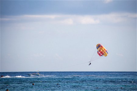Person Parasailing With Boat Over Water photo