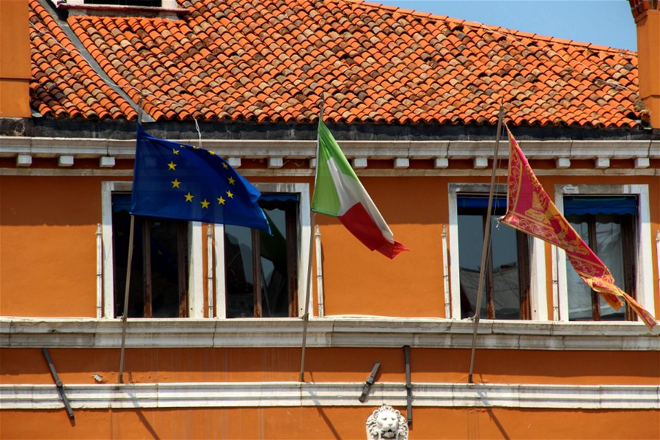 Three Flags On Ocher Colored Building