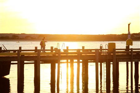 Two People Walking On Pier During Sunset photo