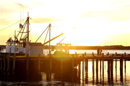 Sunset Behind Boats Near Dock photo