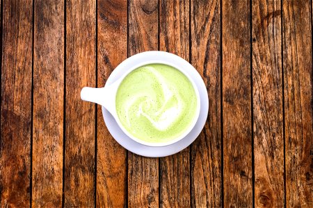 Matcha Latte Cup On Wood Surface photo