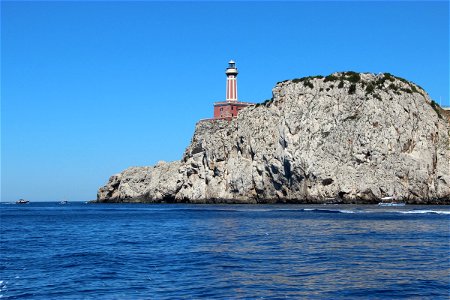 Lighthouse On Rocky Cliffside In Ocean photo